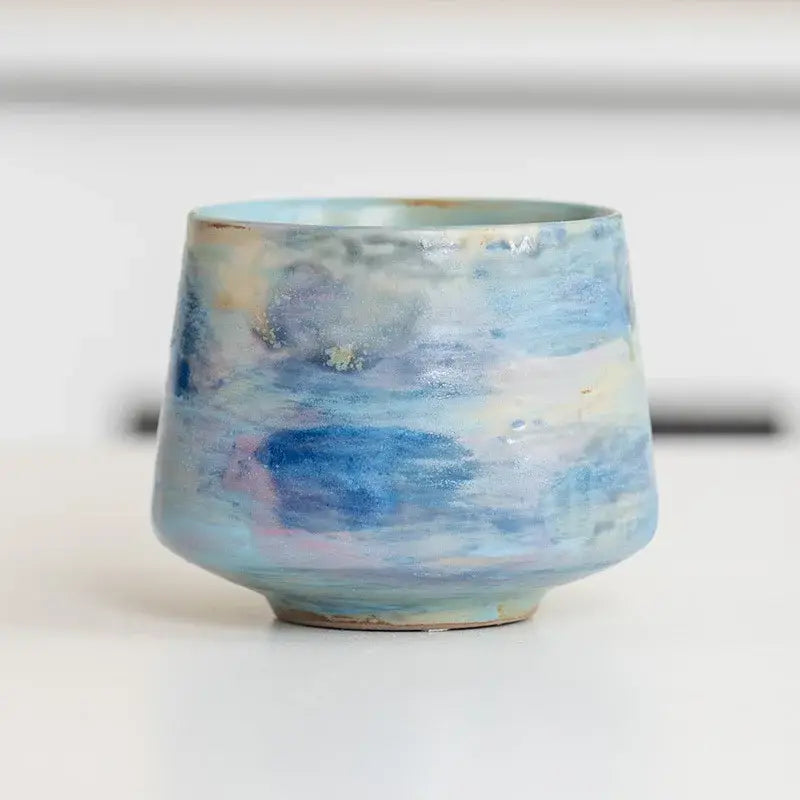 Handcrafted espresso cup in light blue tones, featuring a unique artistic design and textured finish