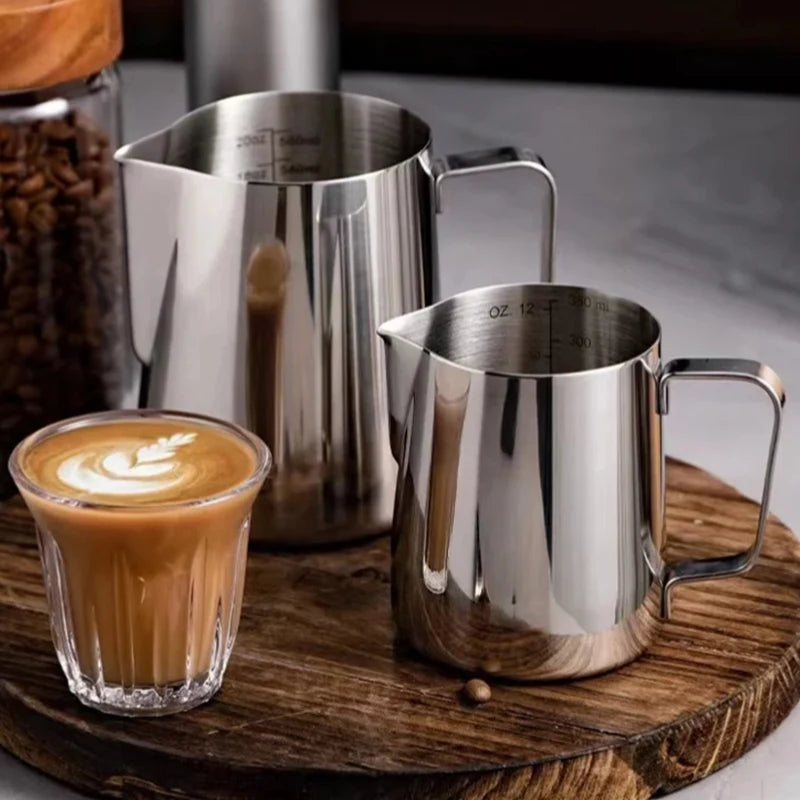Professional barista milk pitcher set in stainless steel with a latte art coffee mug on a wooden tray