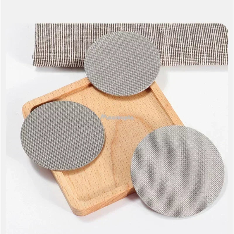 Set of three reusable coffee filter screens placed on a wooden tray for eco-friendly brewing