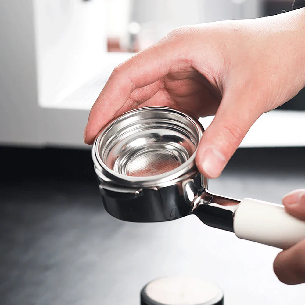 Close-up of a hand holding an espresso filter basket for home use ready for coffee preparation