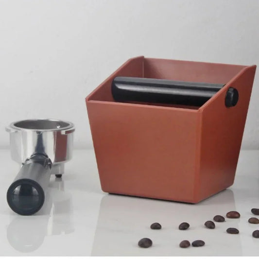 UK Espresso anti slip coffee knock box in brown with a portafilter and scattered coffee beans