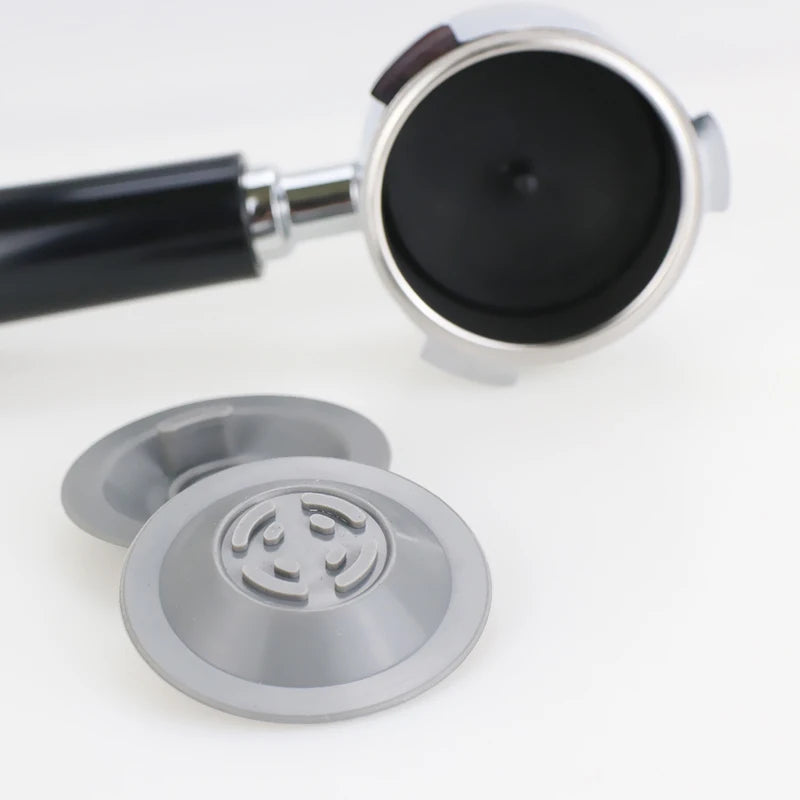 Backflush portafilter disc set in silver with a black handle portafilter for espresso machines